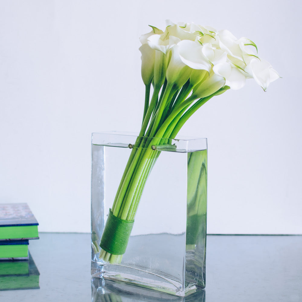 white calla lilies in glass column vase Calla Lilies Floral Arrangement - Empty Vase